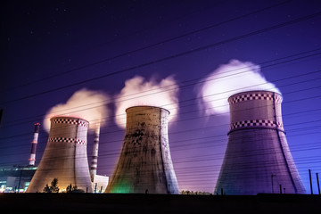 Thermal power plant and cooling towers at night near the city