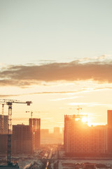  Panorama of construction at sunset. Construction of a residential complex with cranes.