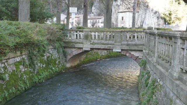 Pioraco, Italy - December 26, 2019: The waters of the power river that flow under the Pioraco bridge.