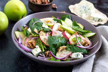 Tasty diet fitness salad with spinach, apples, red onions, blue cheese, nuts. Proper nutrition.