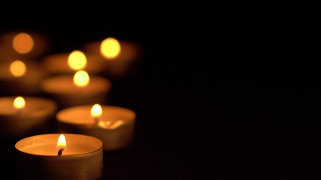 Slow motion white candles light up flames fire on isolated black background. Use in romantic dinner, warm and relax peace maditaion, use for spiritual religion church decotion and Halloween graveyard