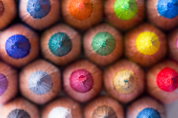 Colored wooden artistic graphite pencils tips in close-up background. Colored sharp pencil leads of multi-colored pencils in macro.