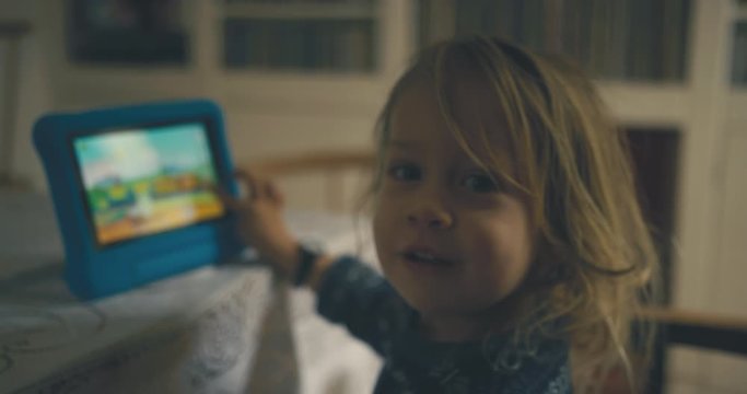 Toddler playing game on tablet at home