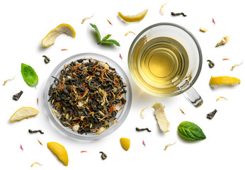 Groene thee met natuurlijke aromatische toevoegingen en een kopje. Bovenaanzicht op witte achtergrond