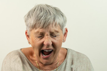 caucasian White haired senior woman with open mouth and eyes closed isolated on White background
