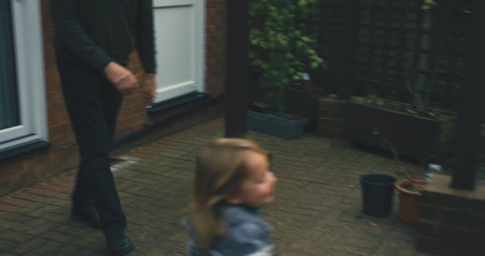 Toddler being chased around the garden by grandfather