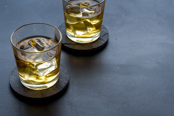 Scotch - two glasses with ice - on black background copy space