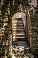 Staircase and entrance. Beautiful warm spring day and archeological ruins at Butrint National Park, Albania, UNESCO heritage. Travel photography with fresh green flora and clear blue sky