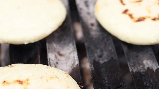 Toasted arepas cooking on the grill