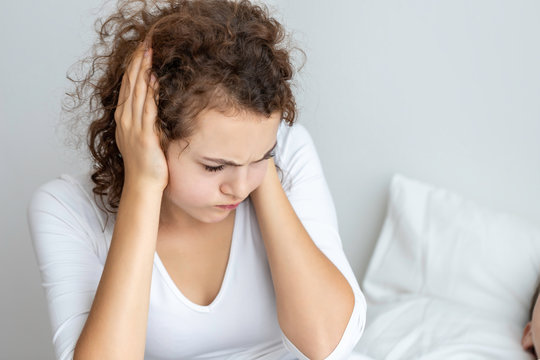 Caucasian couple in pajamas snoring and bad sleeping on the bedroom.Her blocking ears with hands.