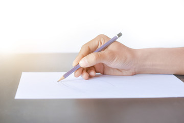 ็Hand with pencil and blank paper isolated on white background. The person who is sketching