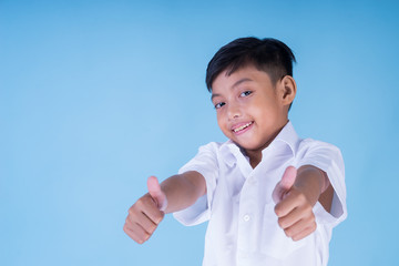 An ecstatic Asian school boy wearing white shirt and blue pants over blue background smiling cheerfully. Back to school concept. Isolated. Landscape orientation. 