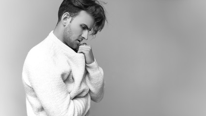 Beautiful portrait of fashion man who thought about something in sweater on a white background. Men's model tests