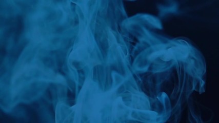 Blue smoke rises up in super slow motion. Abstract foggy isolated texture with mystical effect.