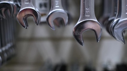 wrenches of different sizes hang on a store stand. The camera moves along the wrenches