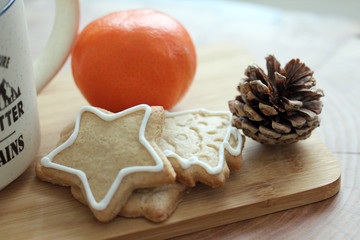 Christmas still life with a cup of tea, tangerine and ginger cookies on a wooden table