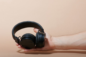 Black headphone lay on hand palm