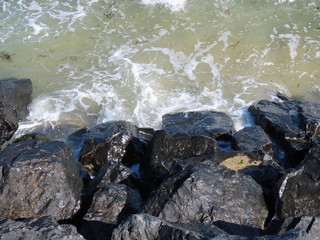 Waves on black rocks