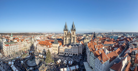 Obraz premium Old Town of Prague, Czech Republic. View on Tyn Church and Jan Hus Memorial on the square as seen from Old Town City Hall during Christmas market. Blue sunny sky
