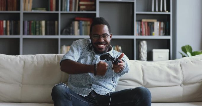 Funny excited african man gamer playing videogame celebrating victory