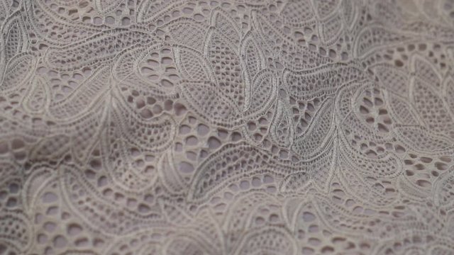 Close-up of beige fabric with lace texture for sewing fashion clothes, luxury evening dresses, wedding dresses by fashion designer.