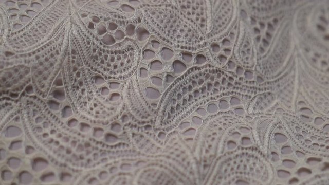 Close-up of beige beautiful lace texture fabric for sewing fashion clothes, luxury evening dresses, wedding dresses.