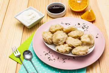 Fish dumplings. The concept of healthy food for children. Sour cream, soy sauce, cutlery. Wood background