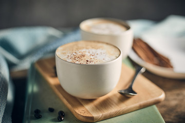 Hot coffee cup and coffee beans on wooden table..