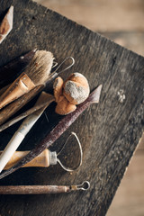 Tools for forming clay on  wooden background..