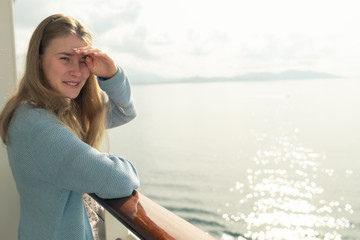 Cruise ship vacation. Teenager girl relaxing on luxury cruise ship balcony. Portrait of a happy beautiful girl on a cruise ship at sunrise