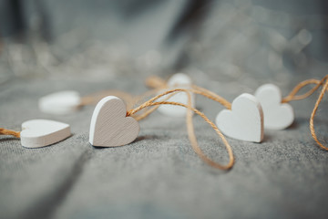 Fototapeta na wymiar Saint Valentine's day card. White wooden hearts on the bright gray background.