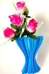 blue cup full of small pink roses