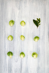 Composition of broccoli cabbage and small green leaf on light wooden background. Vegetarian Food Products