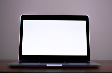 Laptop with blank screen on Empty space white desk, at cafe blurred background of light bokeh.