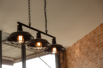 Vintage dome light using filament tungsten gives a warm orange glow in a restaurant decorated with...