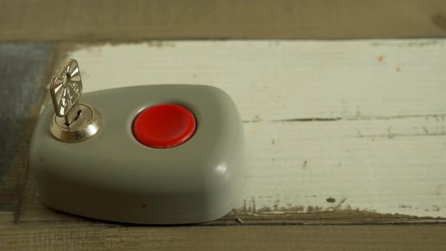 elderly man presses red alarm button. Close-up of a finger on a button. The key to unlock the alarm after the end. Security alert keypad with person arming the system concept for crime prevention 4K