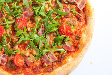 Italian hot pizza with tomato, arugula and pieces of bасon isolated on white background