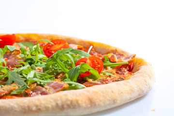 Italian hot pizza with tomato, arugula and pieces of bасon isolated on white background