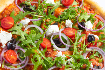 Italian hot pizza with tomato, arugula, cheese Feta, black olives and rings onion isolated on white background