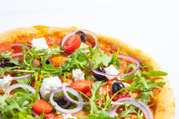 Italian hot pizza with tomato, arugula, cheese Feta, black olives and rings onion isolated on white background