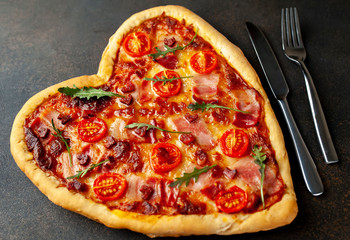 heart-shaped pizza for Valentine's Day on a stone fonya. festive dinner for two for valentines day
