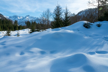 Fototapeta na wymiar View of the Alm valley covered in deep snow with the high rising Austrian alps in the background - near Grünau im Almtal, Salzkammergut, OÖ, Austria