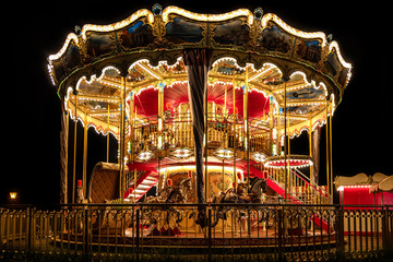Fototapeta premium Illuminated classical carousel at night on a street of Gdansk city