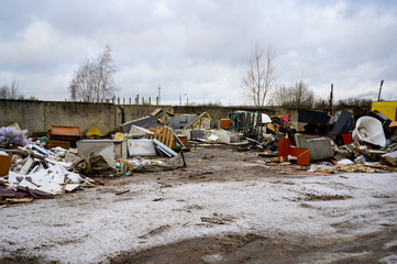 The concept of trash environmental disaster. Photo of a landfill on a street in a city on a cloudy day.