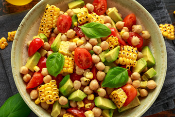 Avocado chickpea salad with grilled sweet corn, tomato and basil. Healthy vegan food