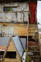 The concept of trash environmental disaster. Photo of a dilapidated hut in a landfill on a street in a city on a cloudy day.