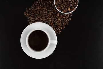 Obraz na płótnie Canvas cup of coffee with coffee seeds on a black background