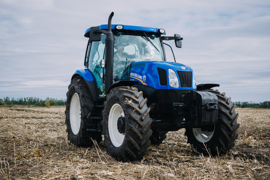 New blue tractor Holland in motion at demonstration field site at agro exhibition AgroExpo. Tractor working on the farm, modern agricultural transport. Kropivnitskiy, Ukraine, September 27, 2018