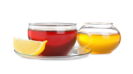 Fresh tea with honey and lemon on white background