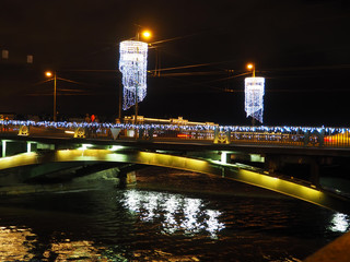 bridge over the river reflecting the lights of illumination in the evening
